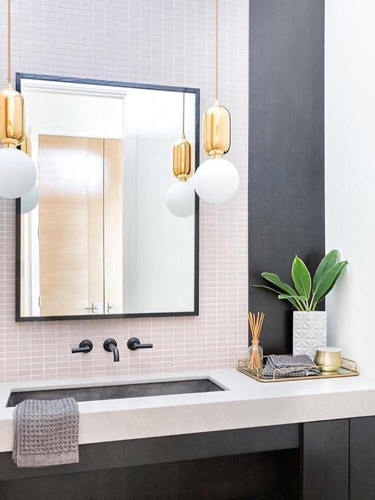 White globe pendants beside a mirror and basin