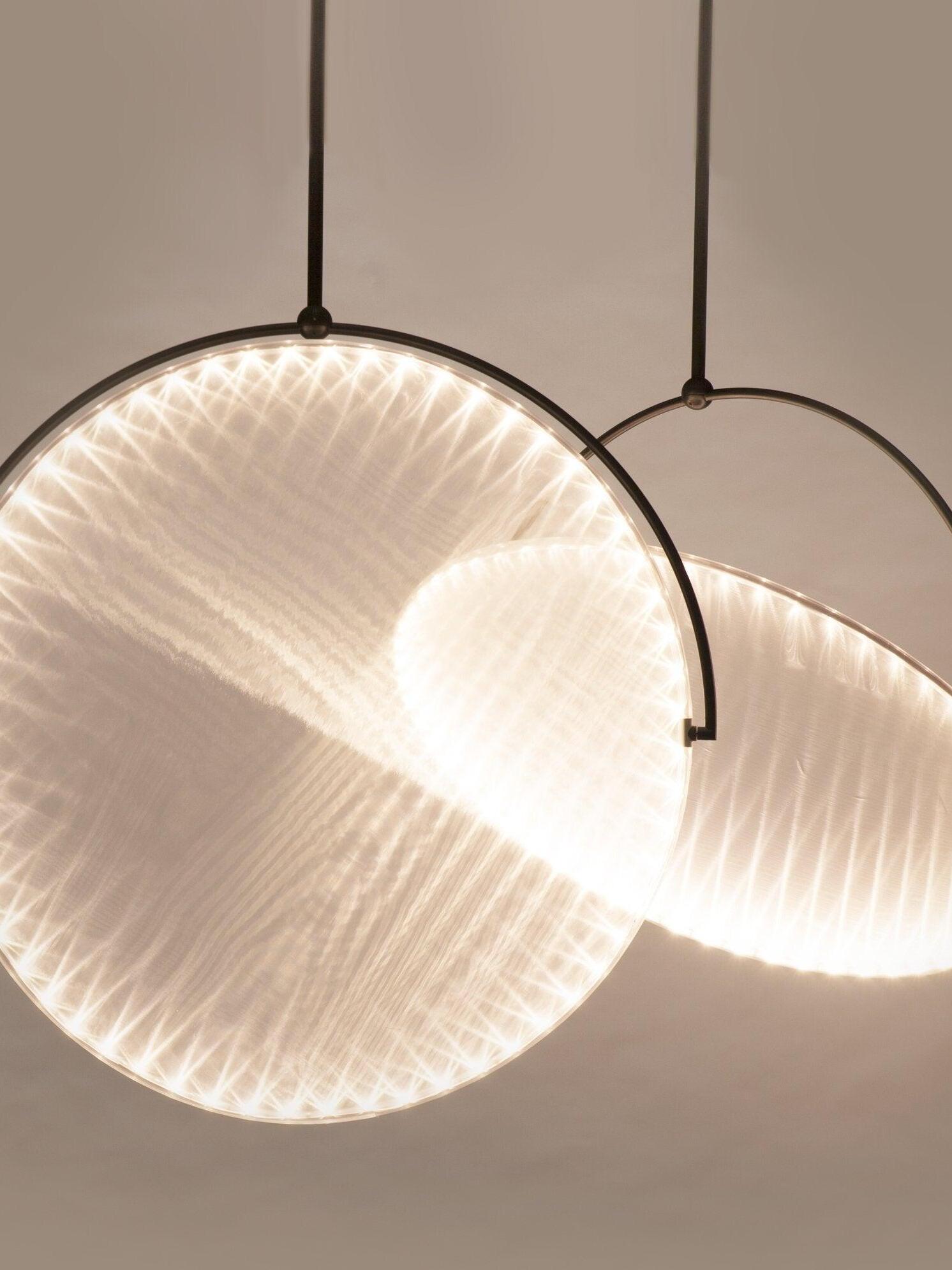 Two suspended discs with fine radial light patterns