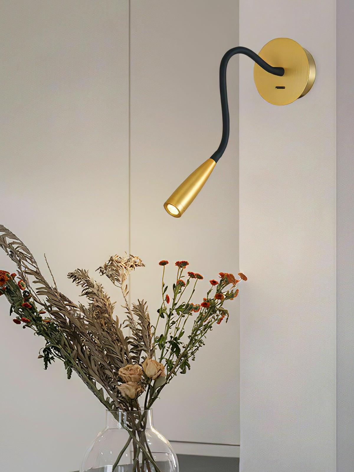Gold Flexi with its tapered head aimed down over dried flowers in a clear vase against a pale wall