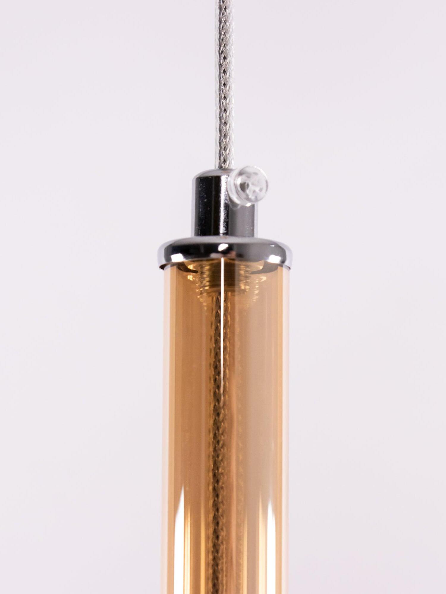 Close view of an amber-looking translucent neck, metallic cap, screw and cord