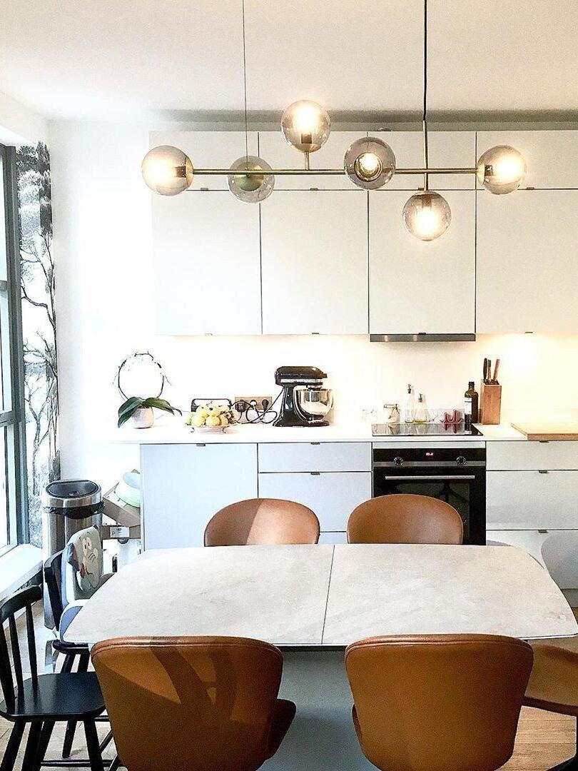 Brass-coloured globe chandelier above a kitchen dining area
