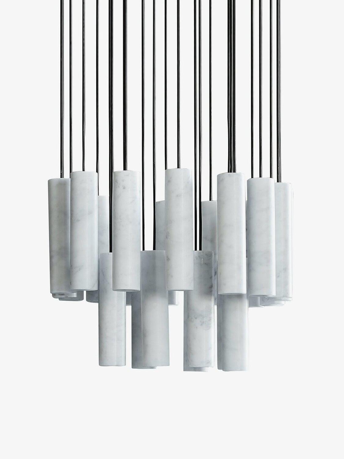 An unlit staggered group of white Silo cylinders and black cords on a pale background