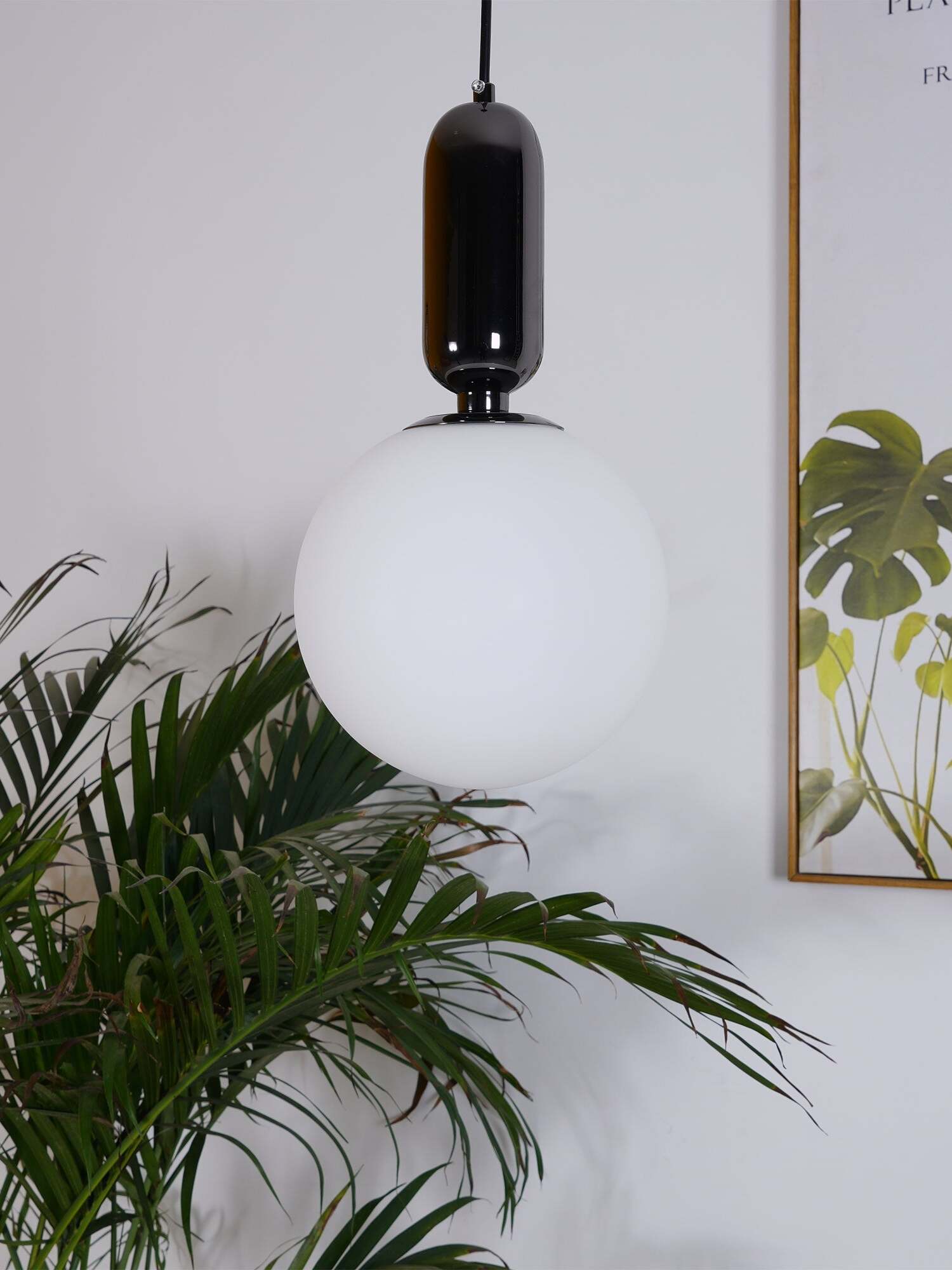 White globe pendant beside green indoor plants