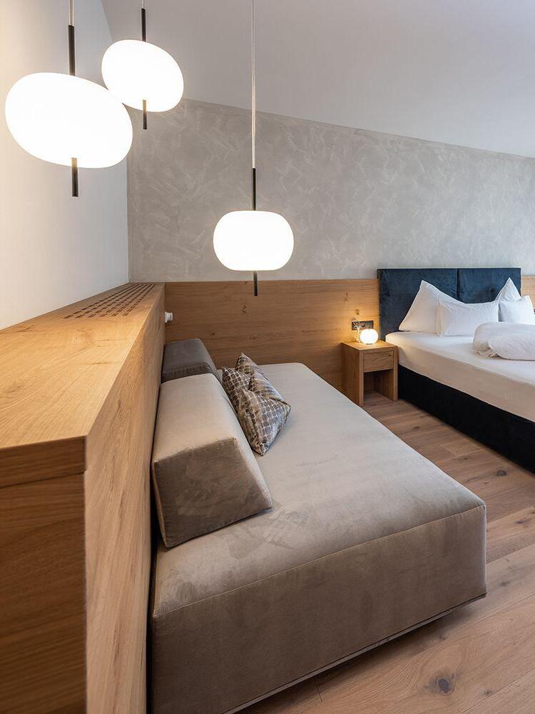White rounded pendants beside a bed and sofa