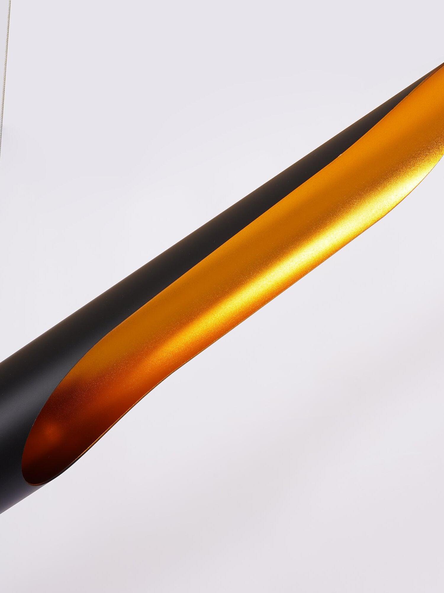 Close-up of the long gold-tone opening and black rim of the metal pipe shade