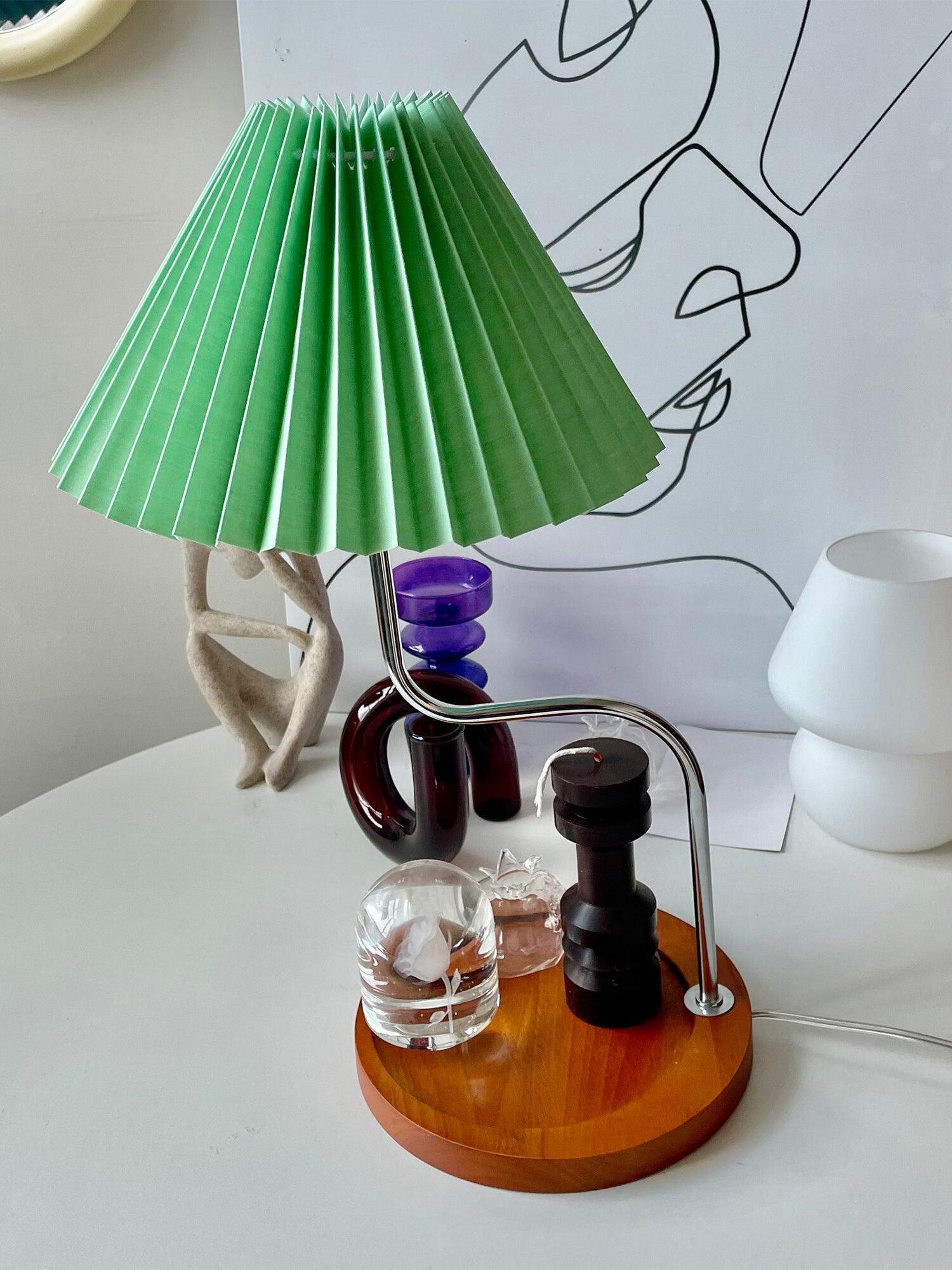 Green pleated shade above round wooden tray