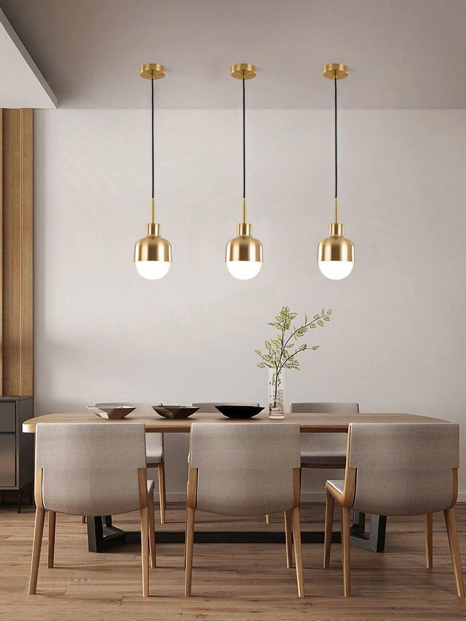 Three Niku pendants with separate round canopies above a wooden dining table and flower vase