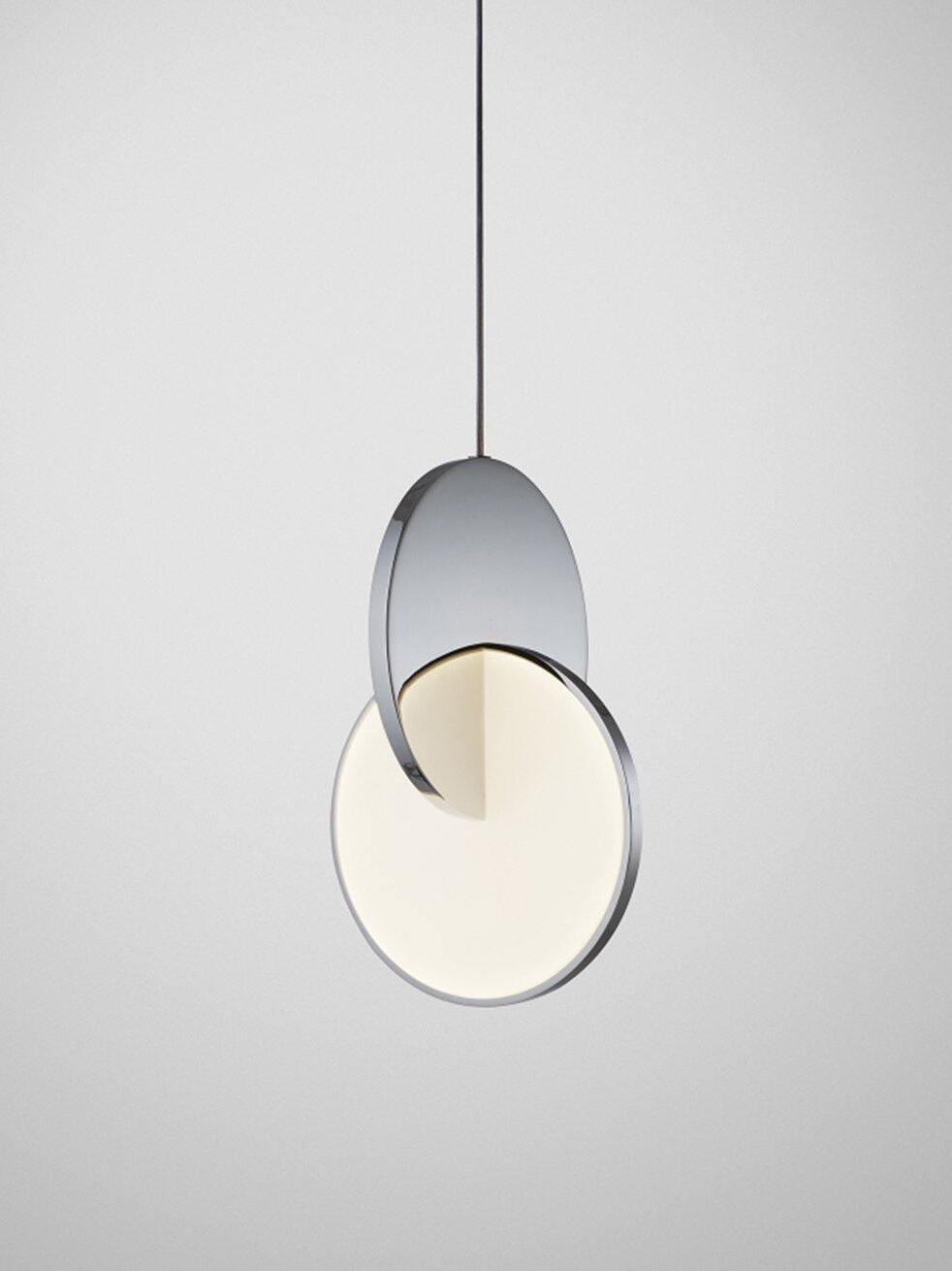 Single chrome disc pendant light with crossing white diffuser and black cord against grey
