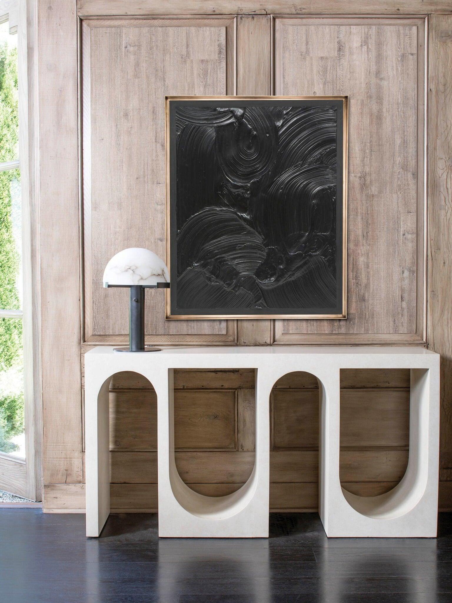 Black column dome lamp beneath framed artwork