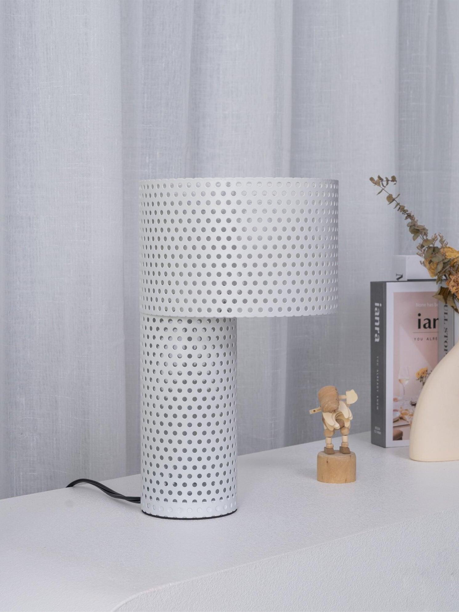 Unlit white metal table lamp near pale curtain