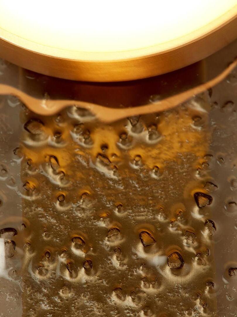 Detail of the textured Modulo glass panel reflecting gold light below a rounded dome