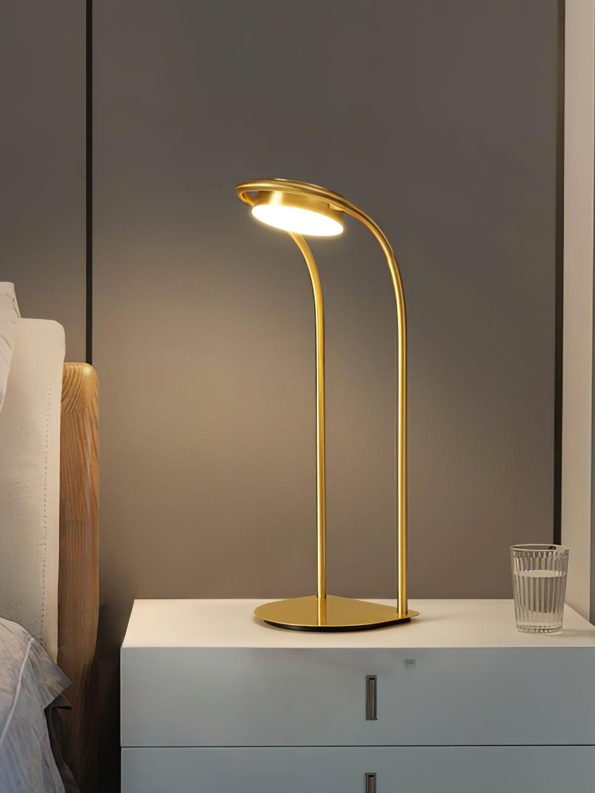 Curved brass LED lamp on white bedside cabinet