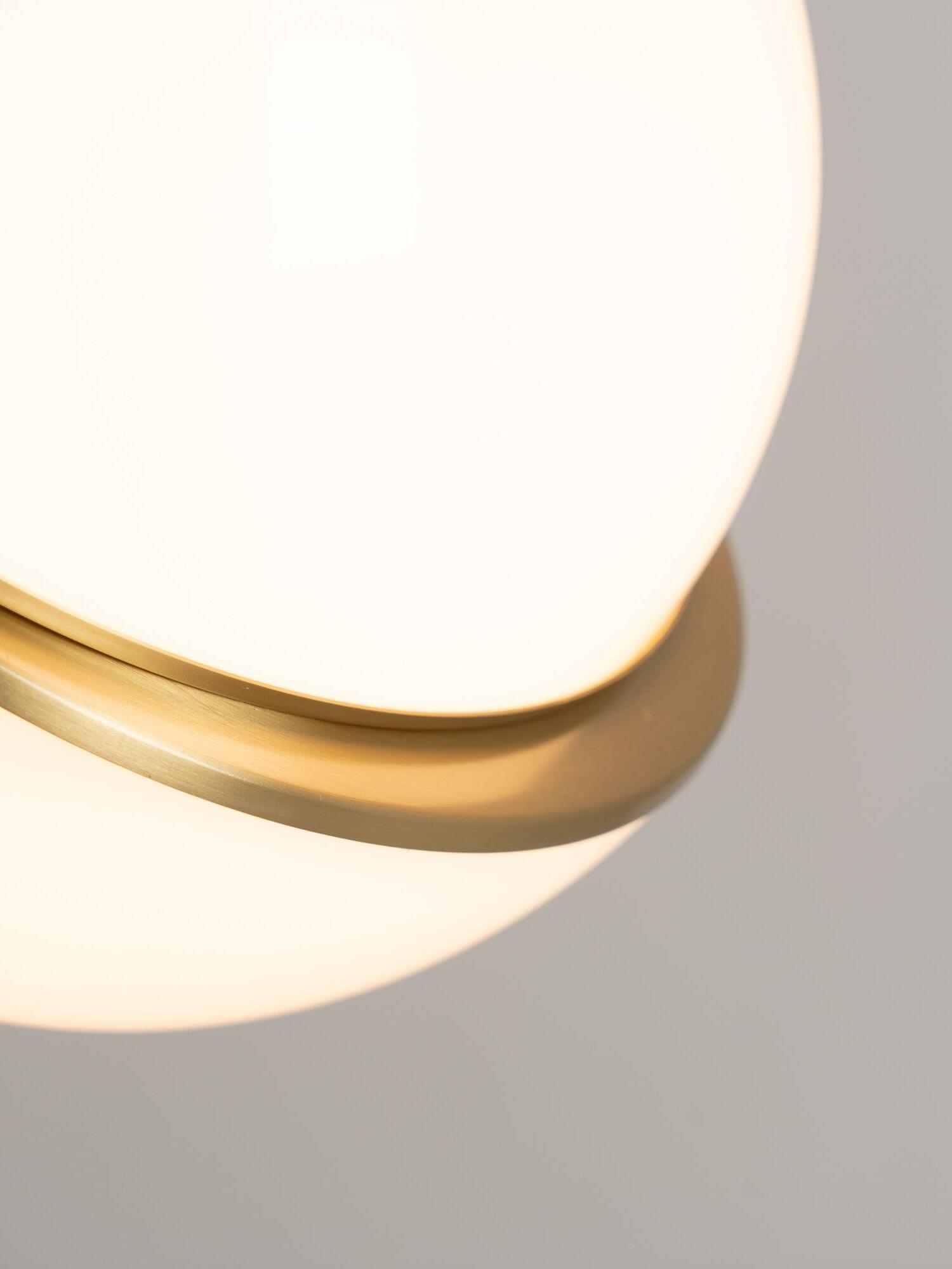 Close detail of the illuminated Crescent white globe surface, curved gold-colour band and offset gap