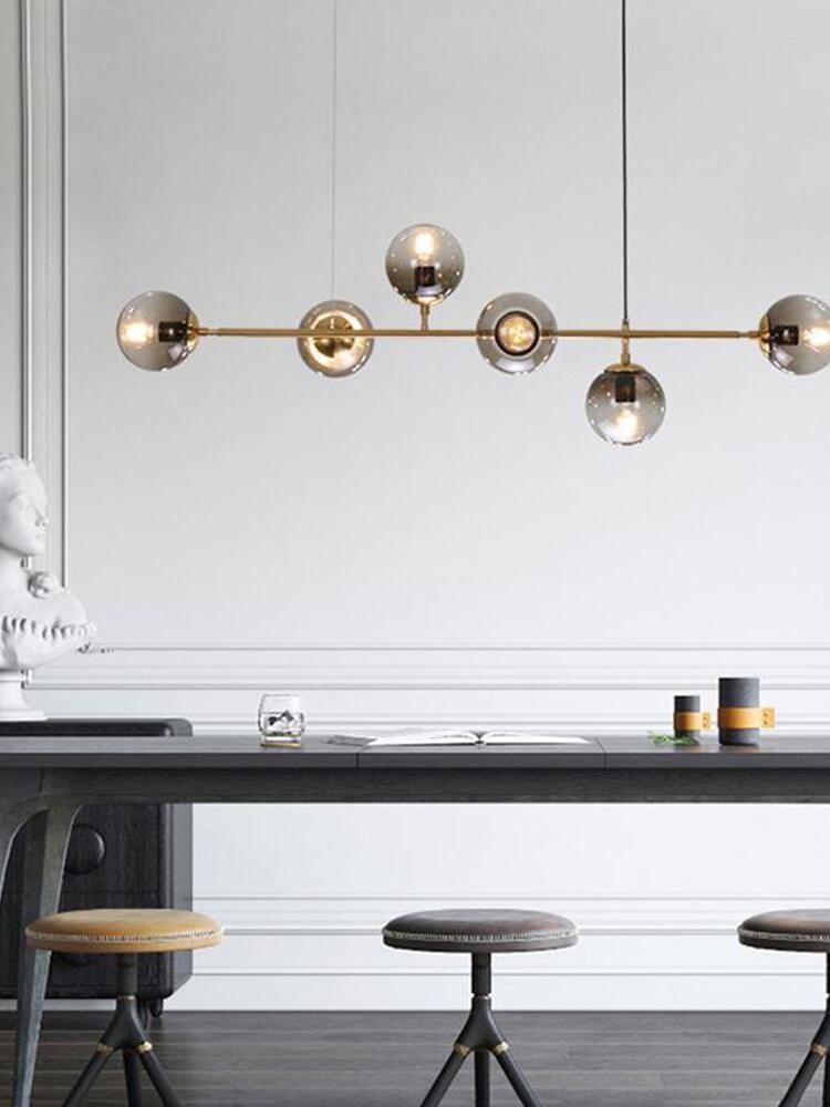Linear globe chandelier above a kitchen counter