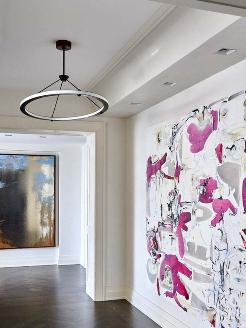 Black ring pendant in hall with abstract wall art