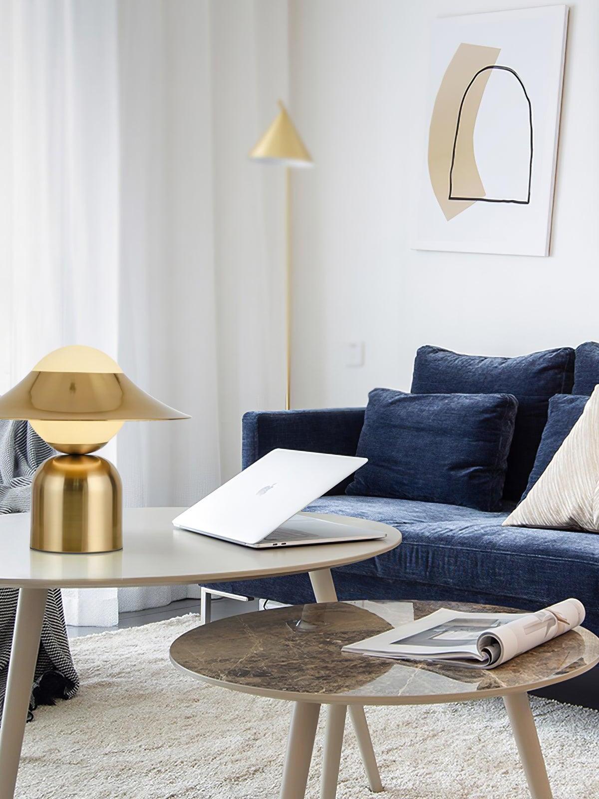 Gold disc lamp beside sofa on small table