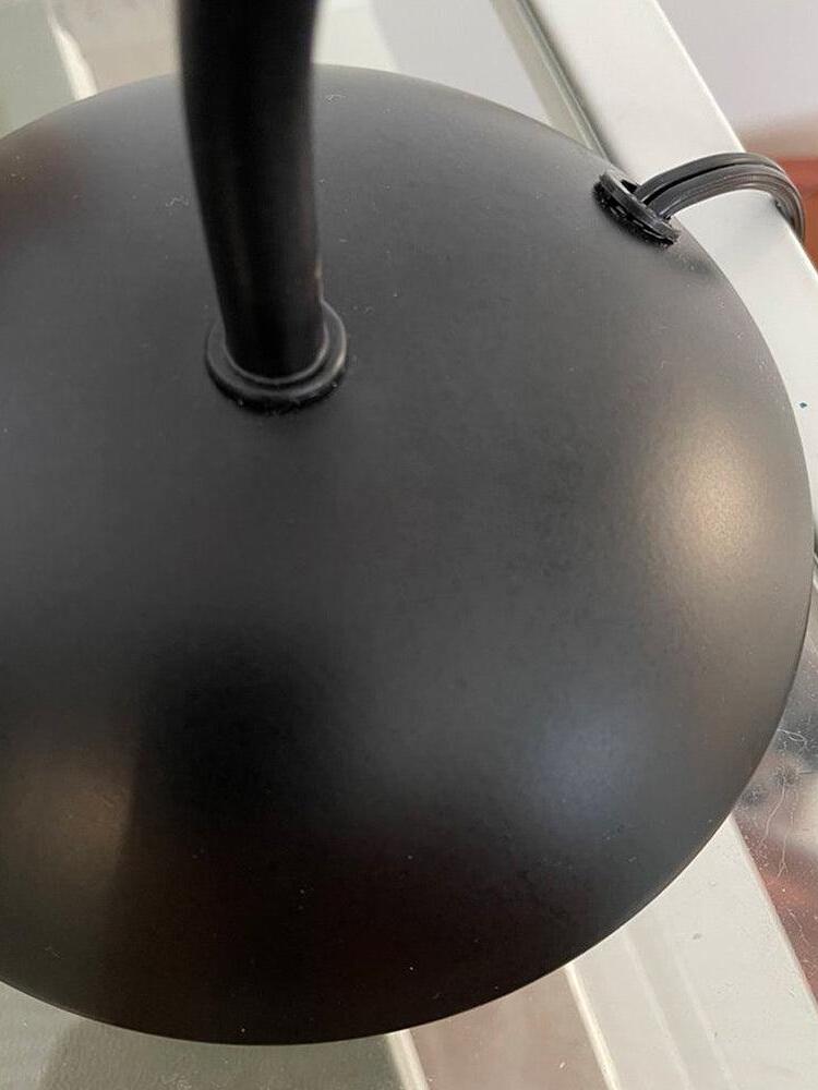 Close view of the black domed lamp base, stem and cable exit