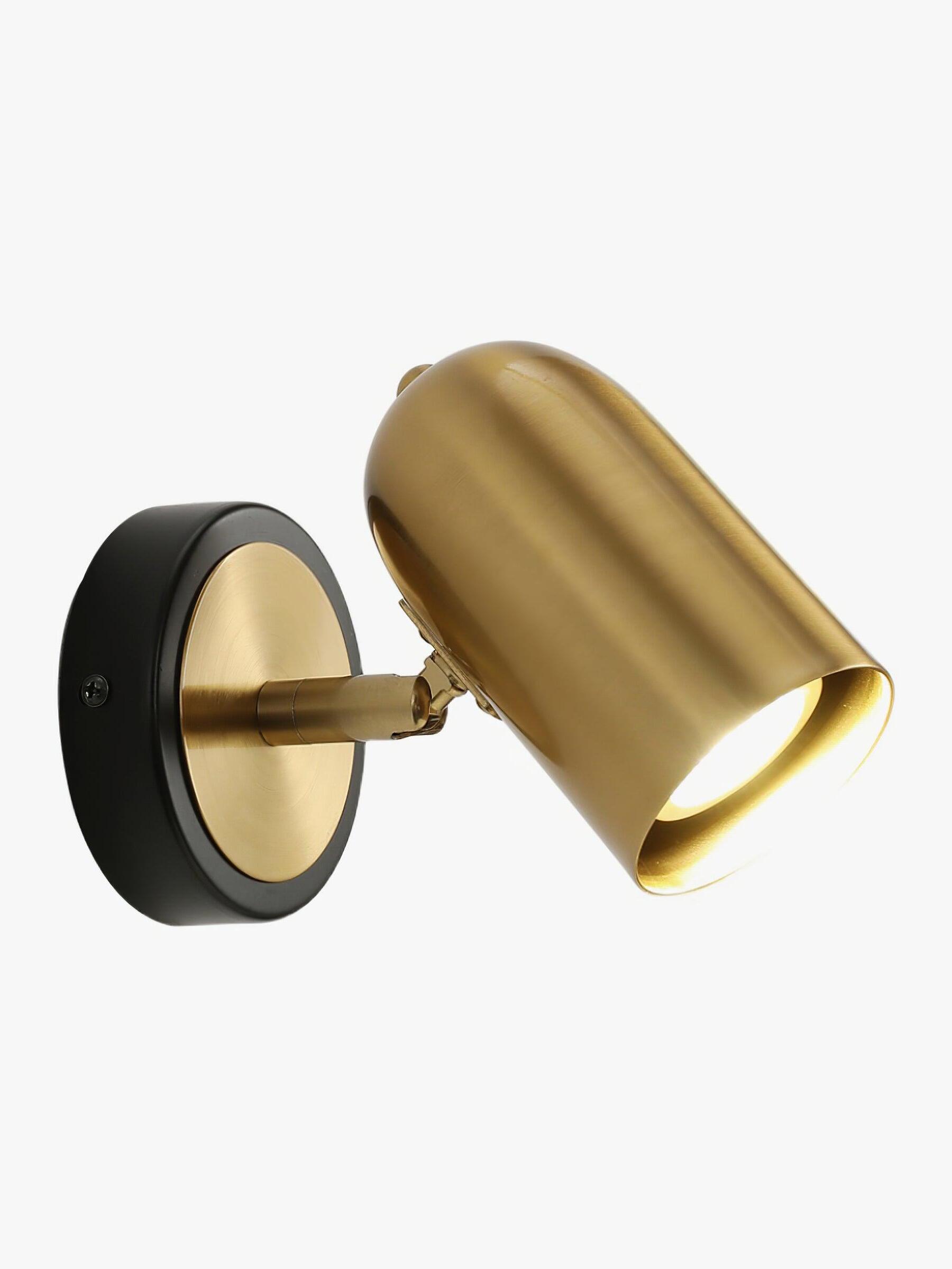 Angled gold cylinder wall lamp on black-rimmed plate