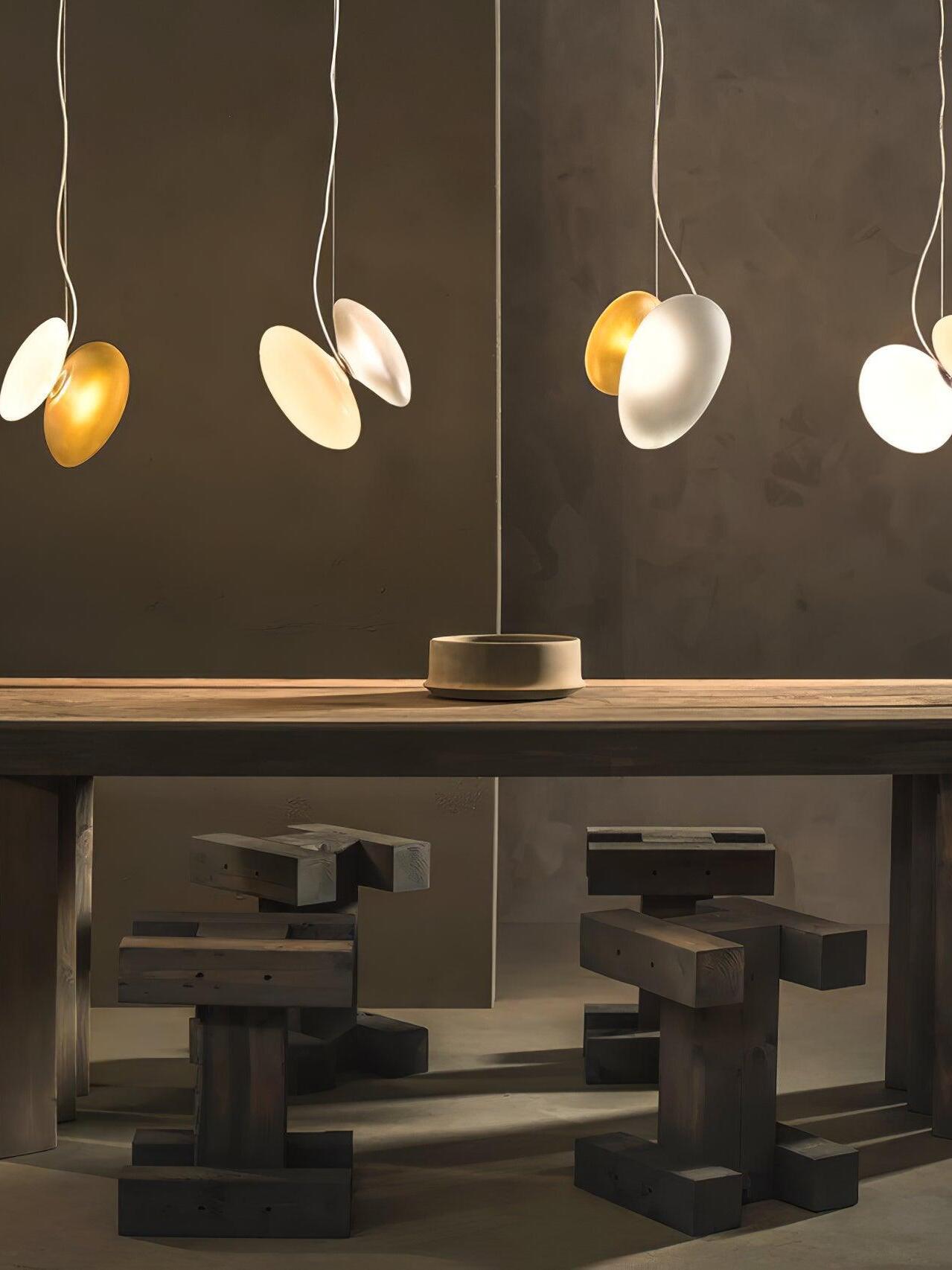 White and gold-tone pebble pendants above a long table