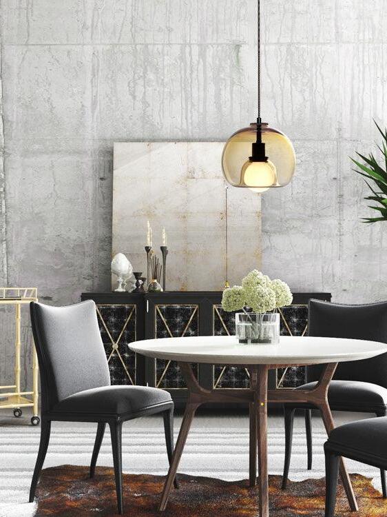 Warm-toned Eres glass pendant above a round dining table.