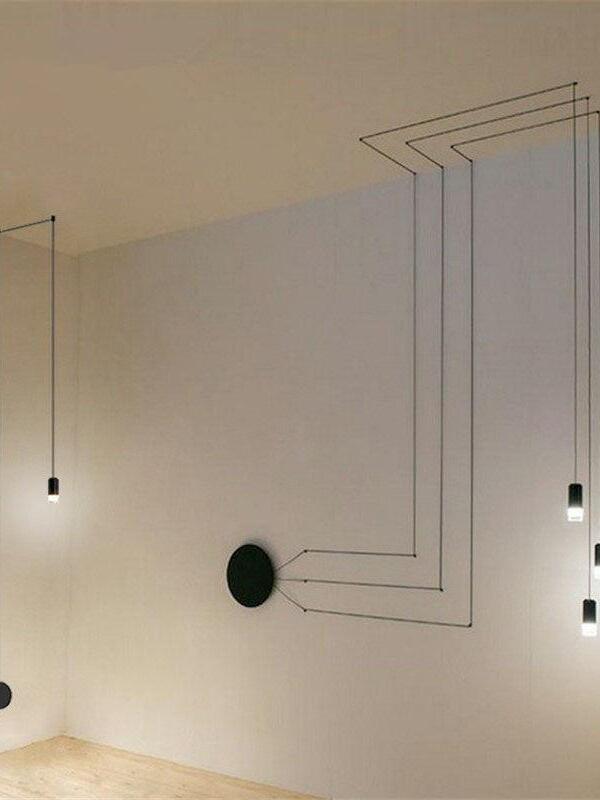 Black cables turning across the ceiling and down a corner wall to a round plate