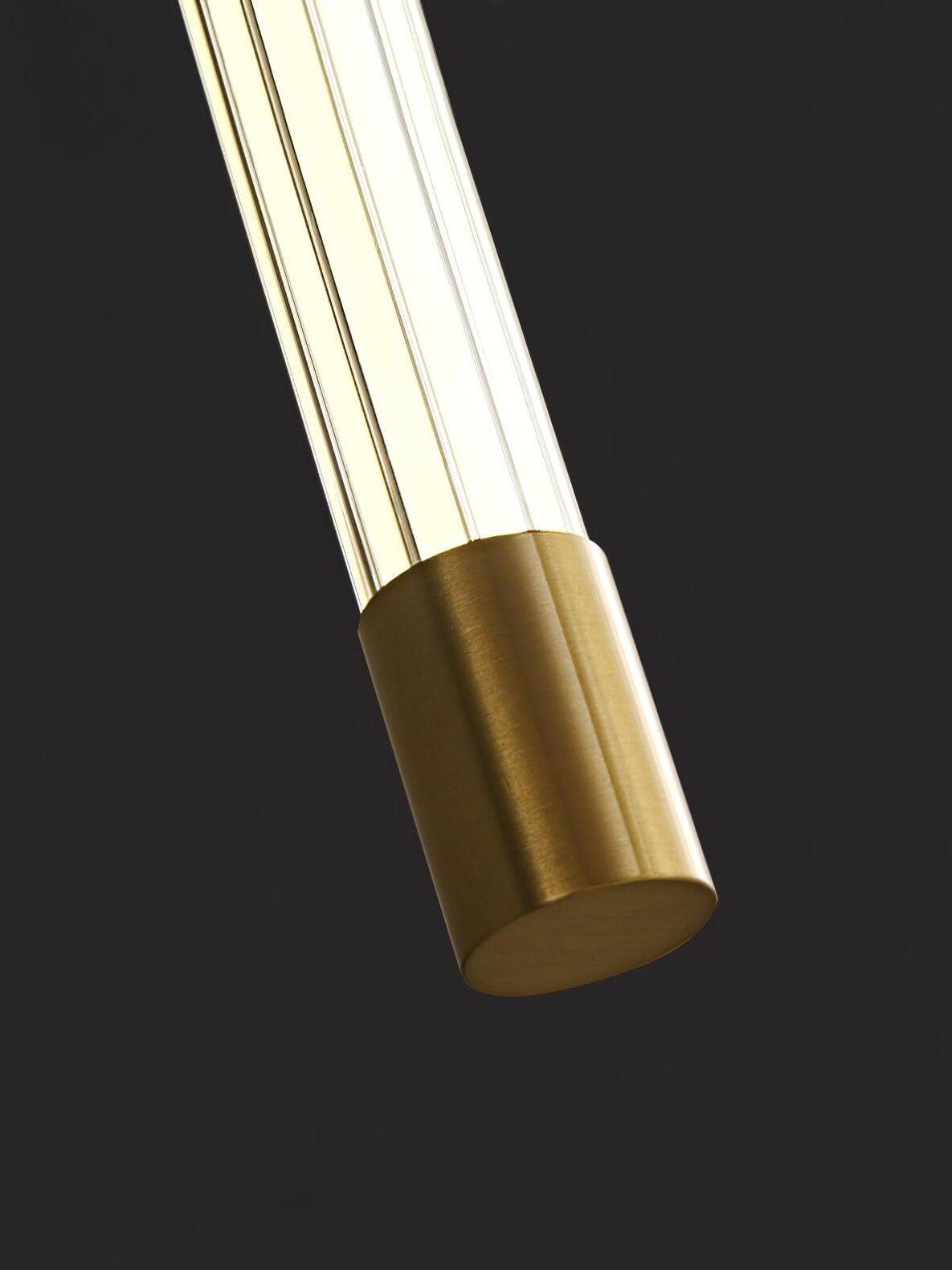 Close view of a brass-tone end cap on a clear ribbed luminous tube against a dark background