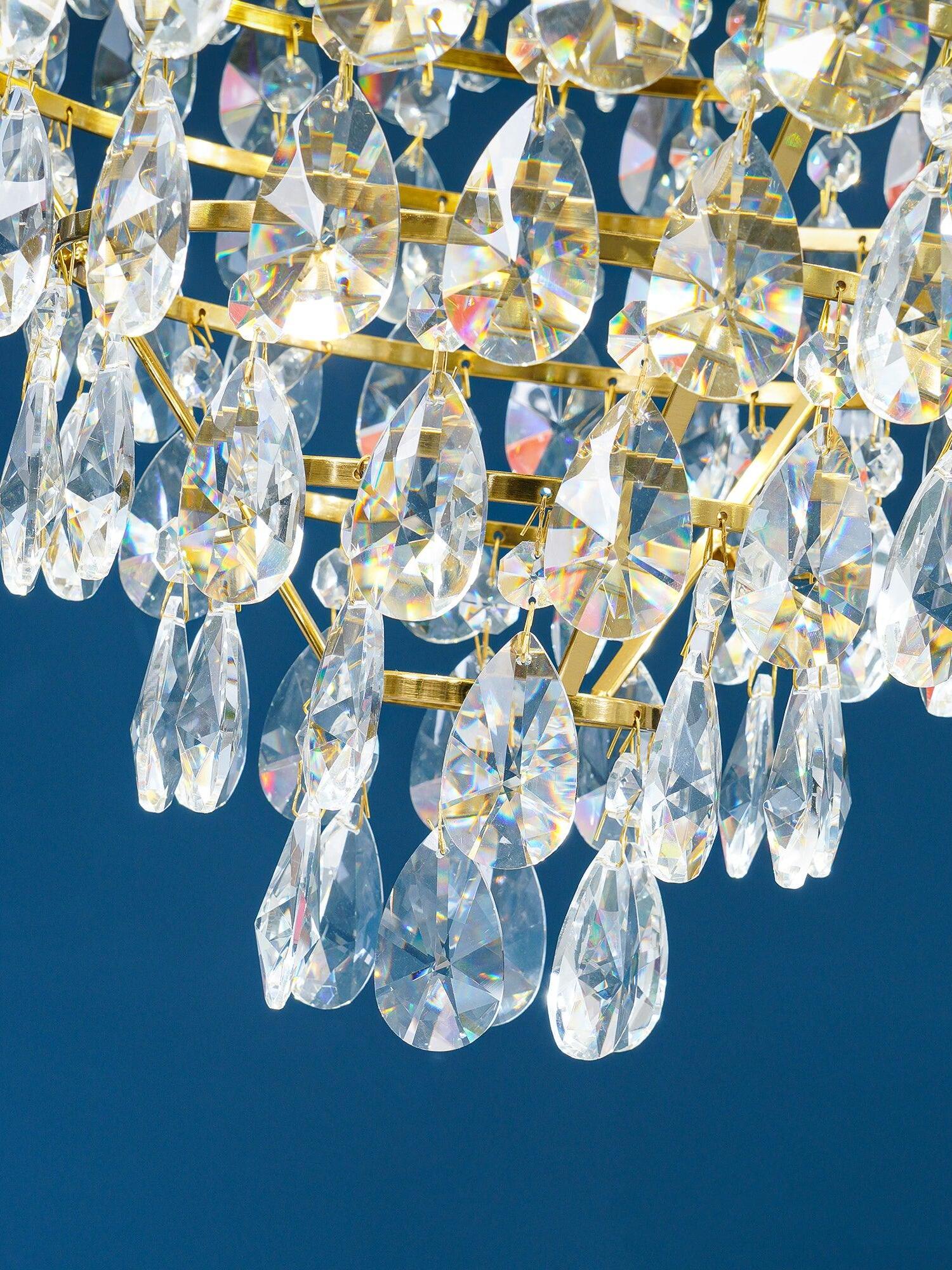 Layered faceted crystal drops and small linking beads photographed against a deep blue background