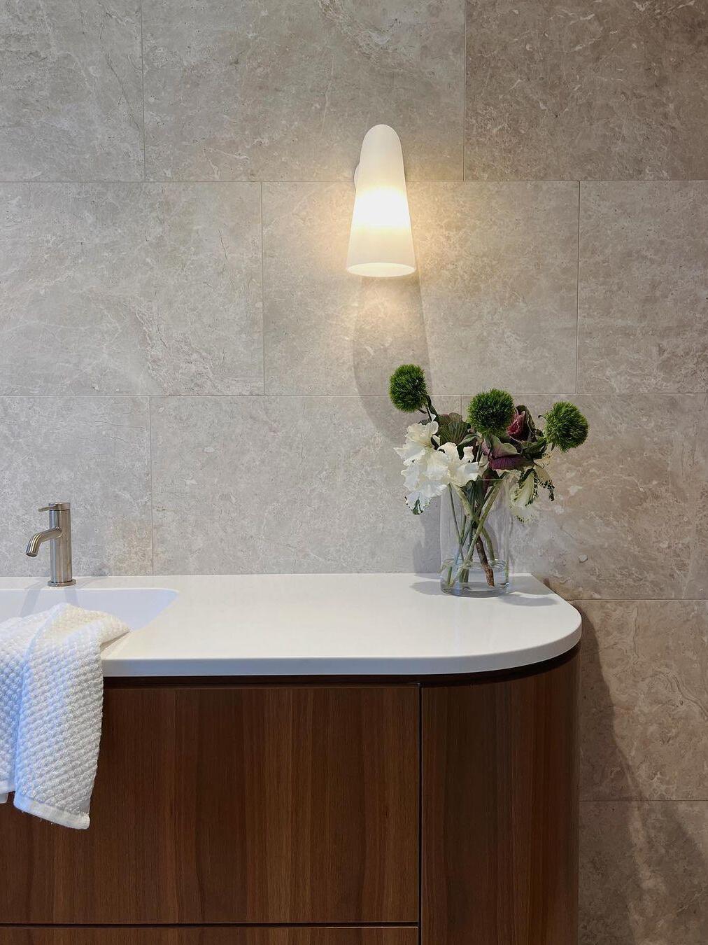 Pale conical shade above a bathroom basin