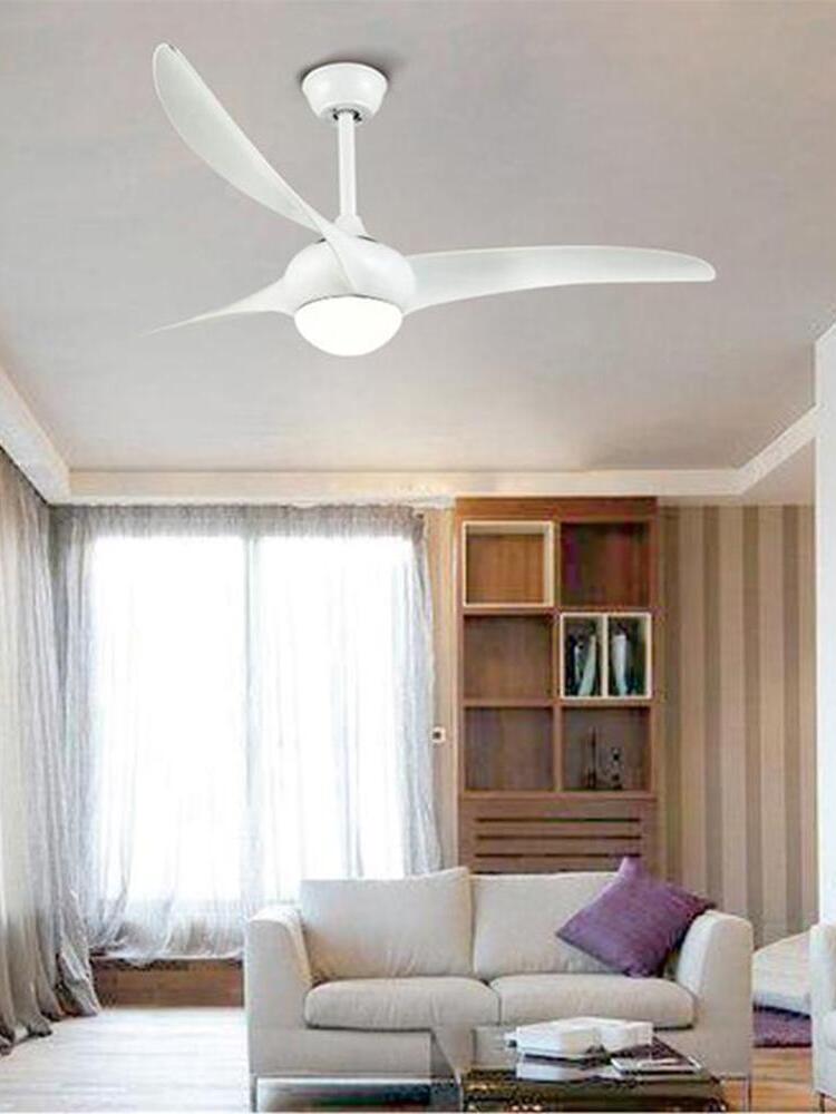 White curved-blade ceiling fan with bright round light above a white sofa, purple cushion and coffee table
