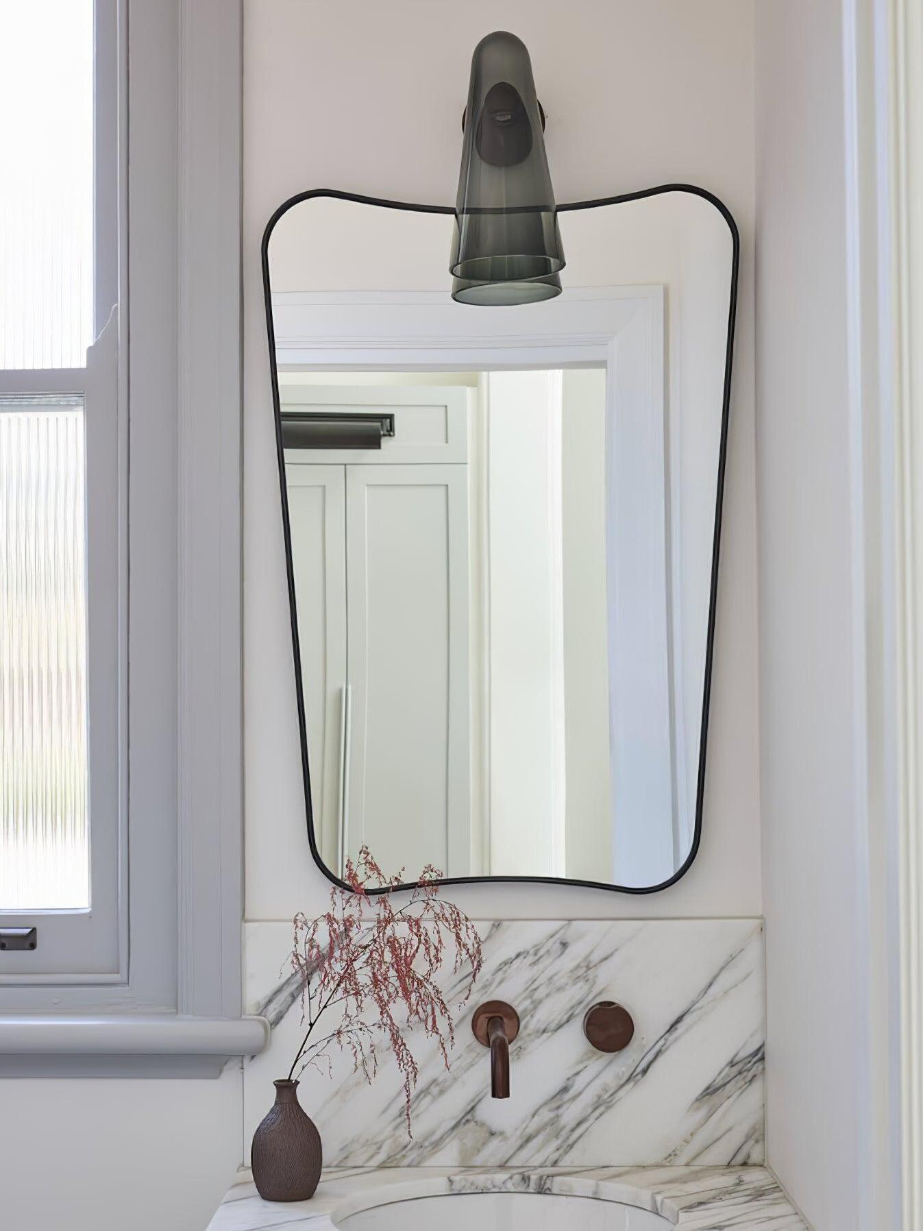 Dark glass shade over a mirror in a room scene