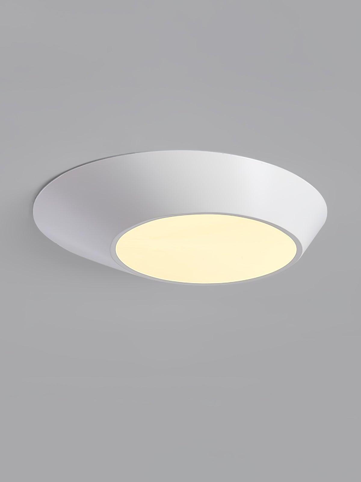 White angled ceiling light with a warm-looking circular diffuser against gray