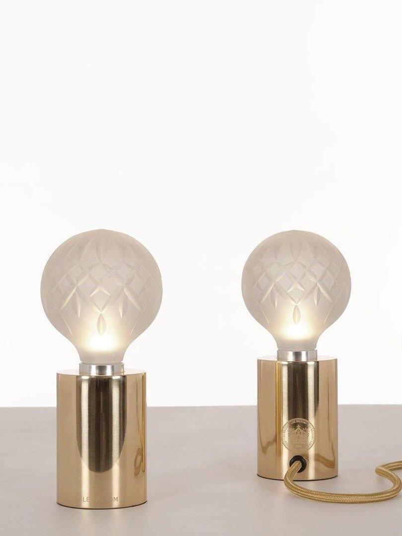 Two frosted-looking patterned globes on polished cylindrical bases
