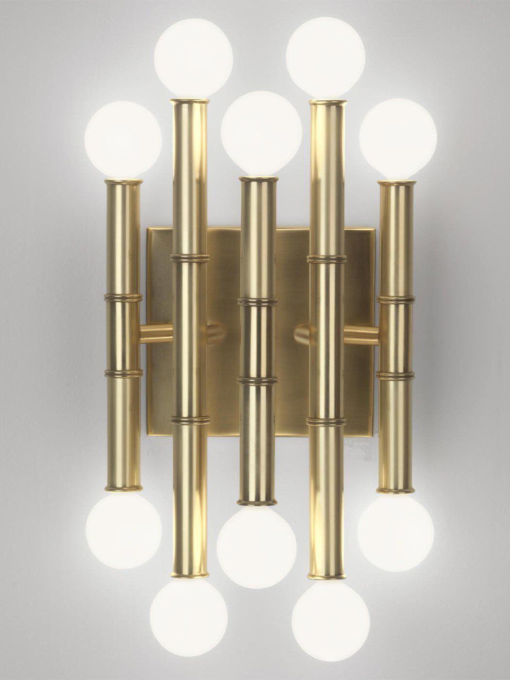 Close front view of gold-tone Meurice with jointed metal stems, glowing globe bulbs and a rectangular backplate