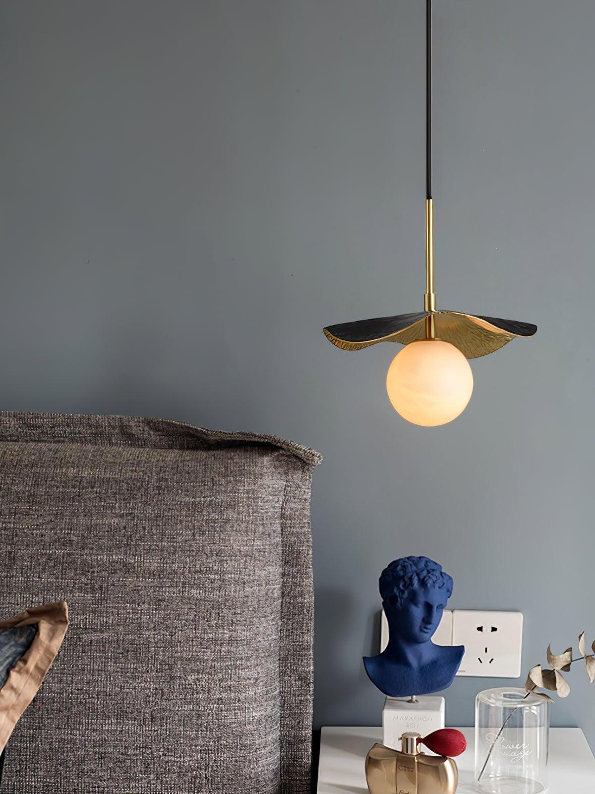 Single leaf and globe pendant beside sofa