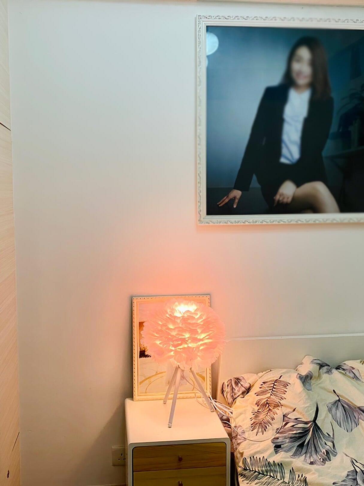 Pink feather table lamp on small bedside cabinet
