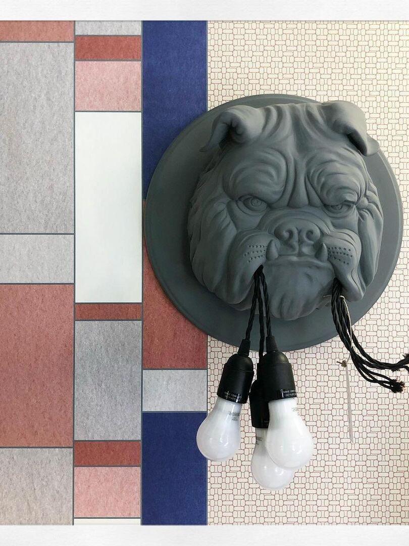 Grey bulldog head with exposed bulbs against patterned panels