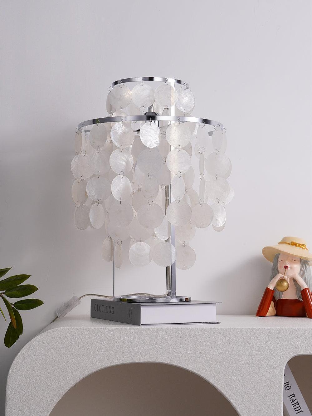 Angled unlit shell lamp on book on white console