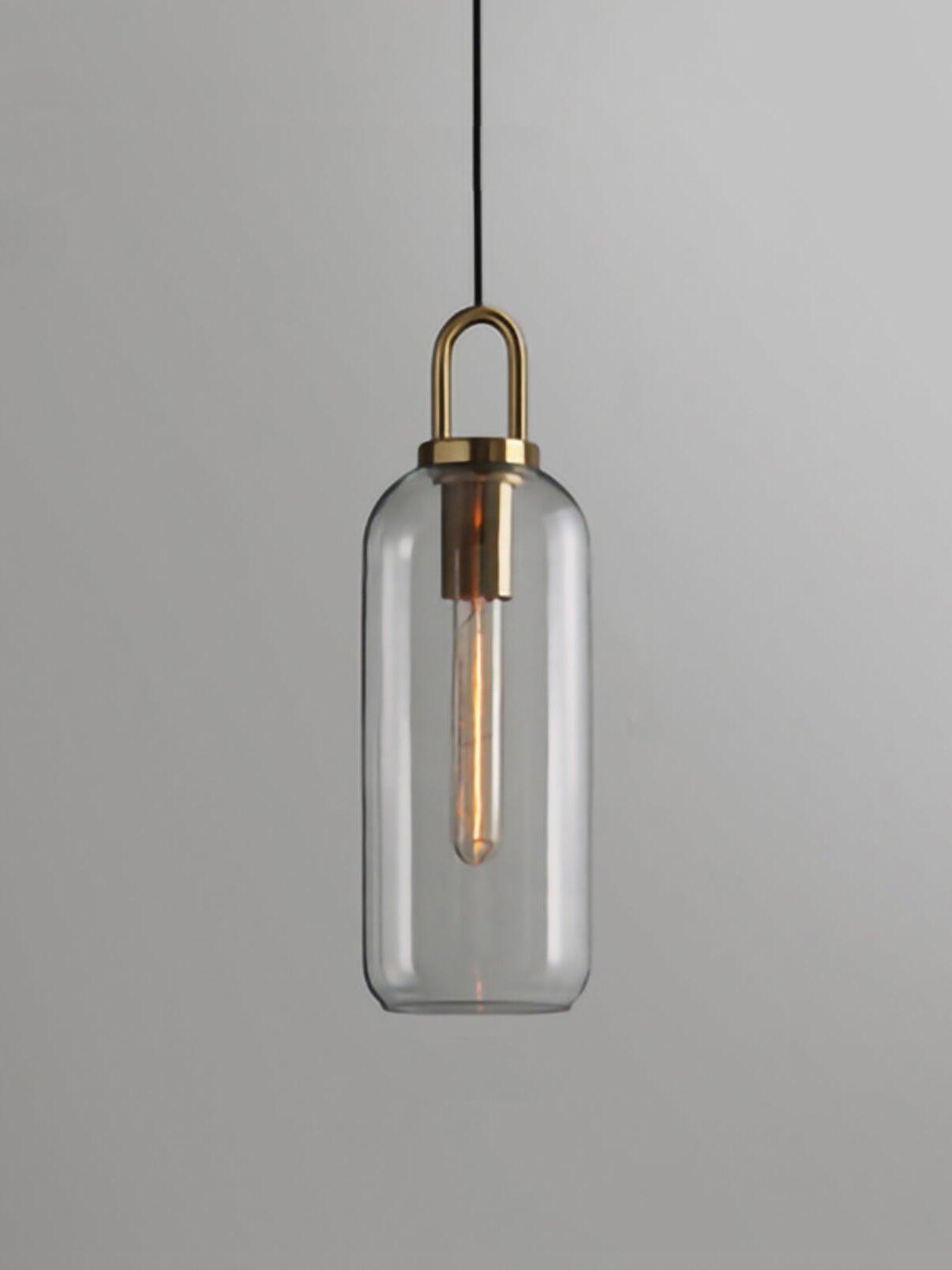 Slender clear capsule glass pendant with an elongated bulb and metal loop