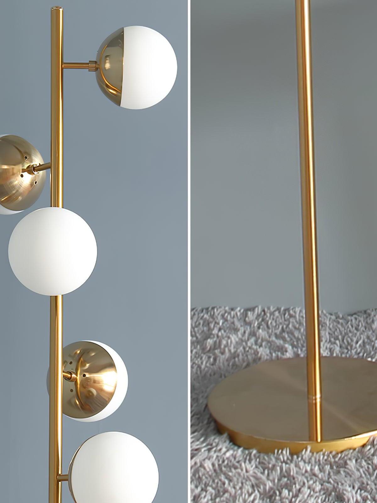 Close view of gold lamp stem, white globes and base