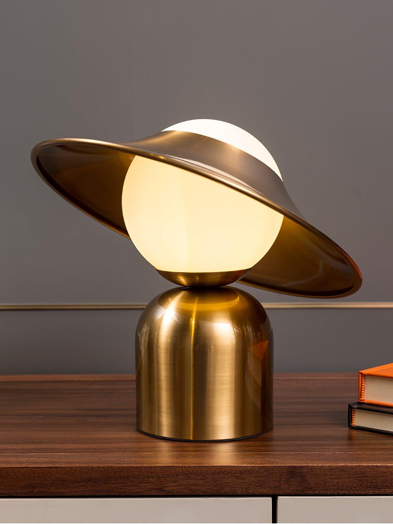 Lit gold disc lamp on dark wooden surface