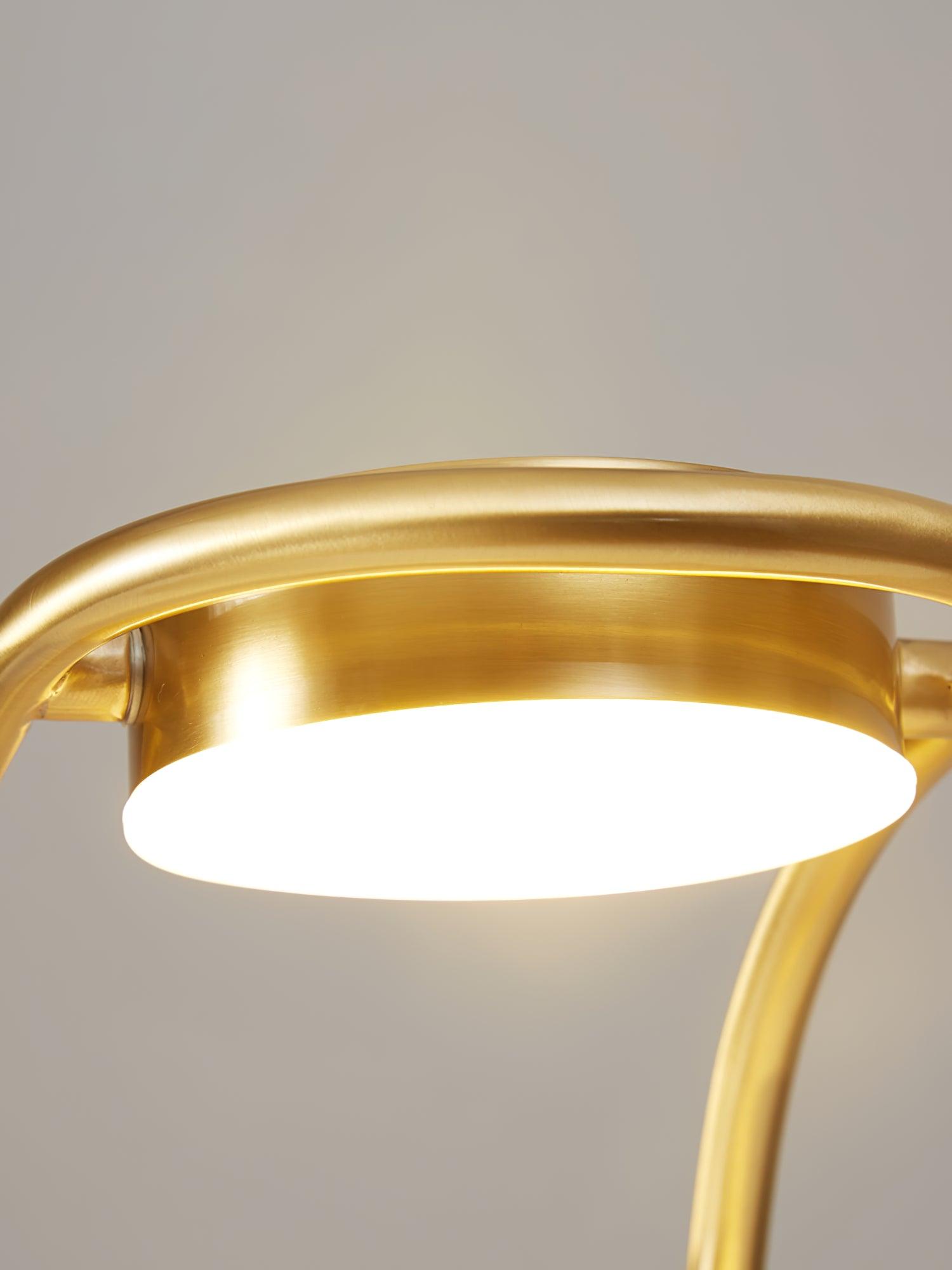 Close view of round integrated LED head on brass arch