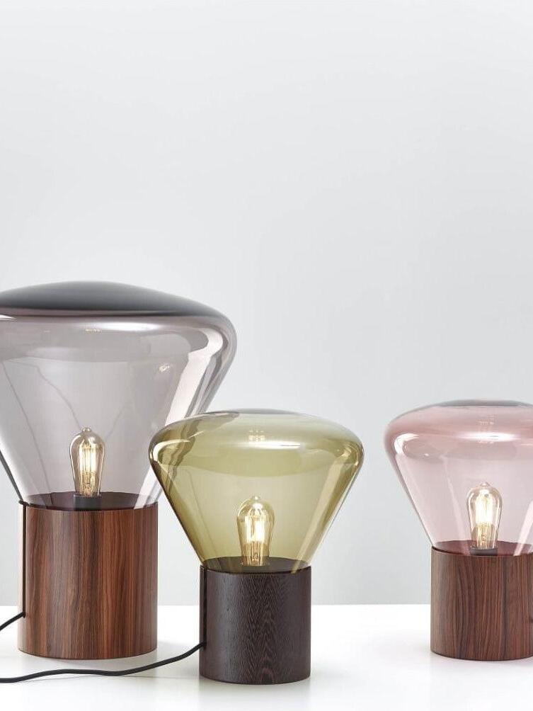 Three glass lamps with smoky, yellow-green and pale pink shades on dark bases