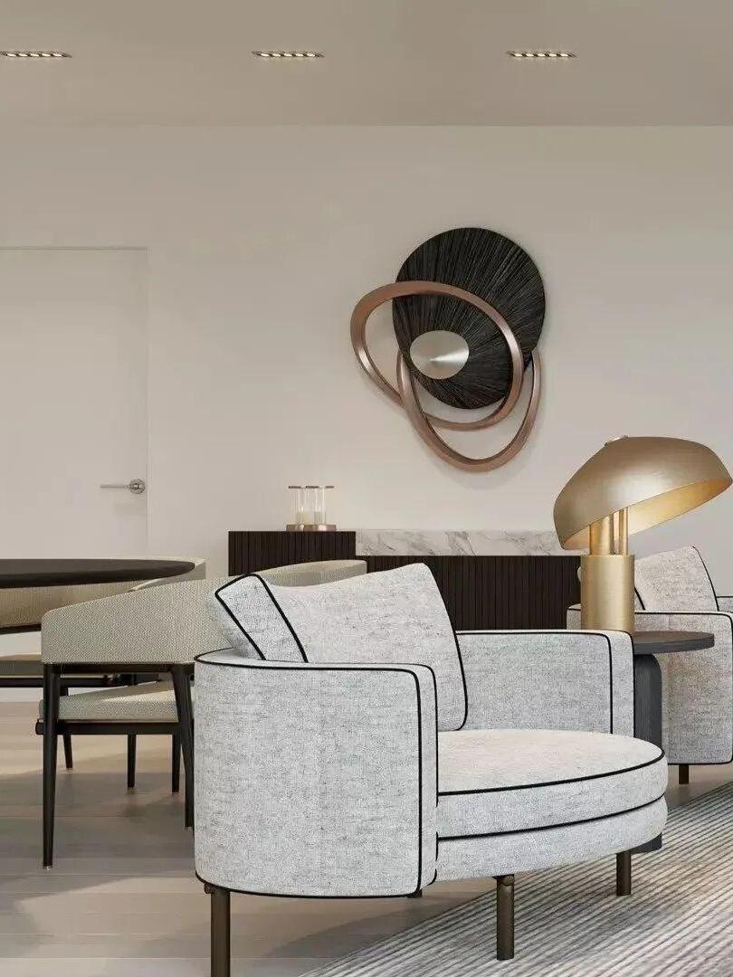 Gold table lamp beyond pale upholstered chair