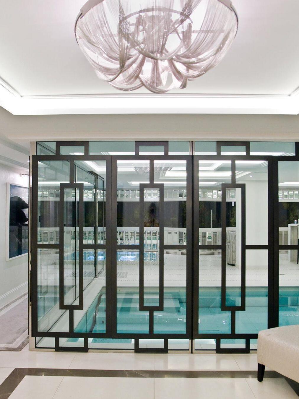 Silver chain ceiling light above dark framed partition