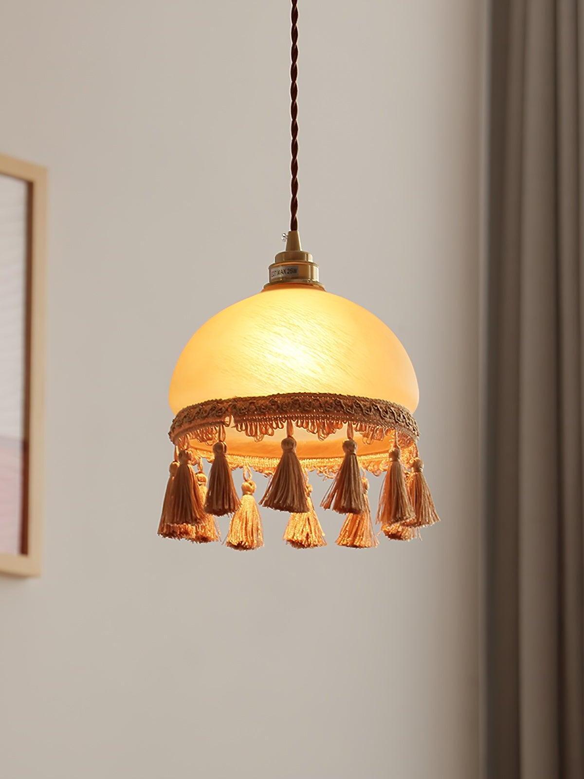 Close room view of lit yellow dome and ornate fringe