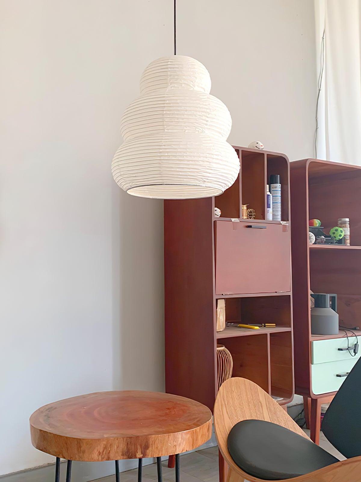 White ribbed paper pendant beside bookshelf and table