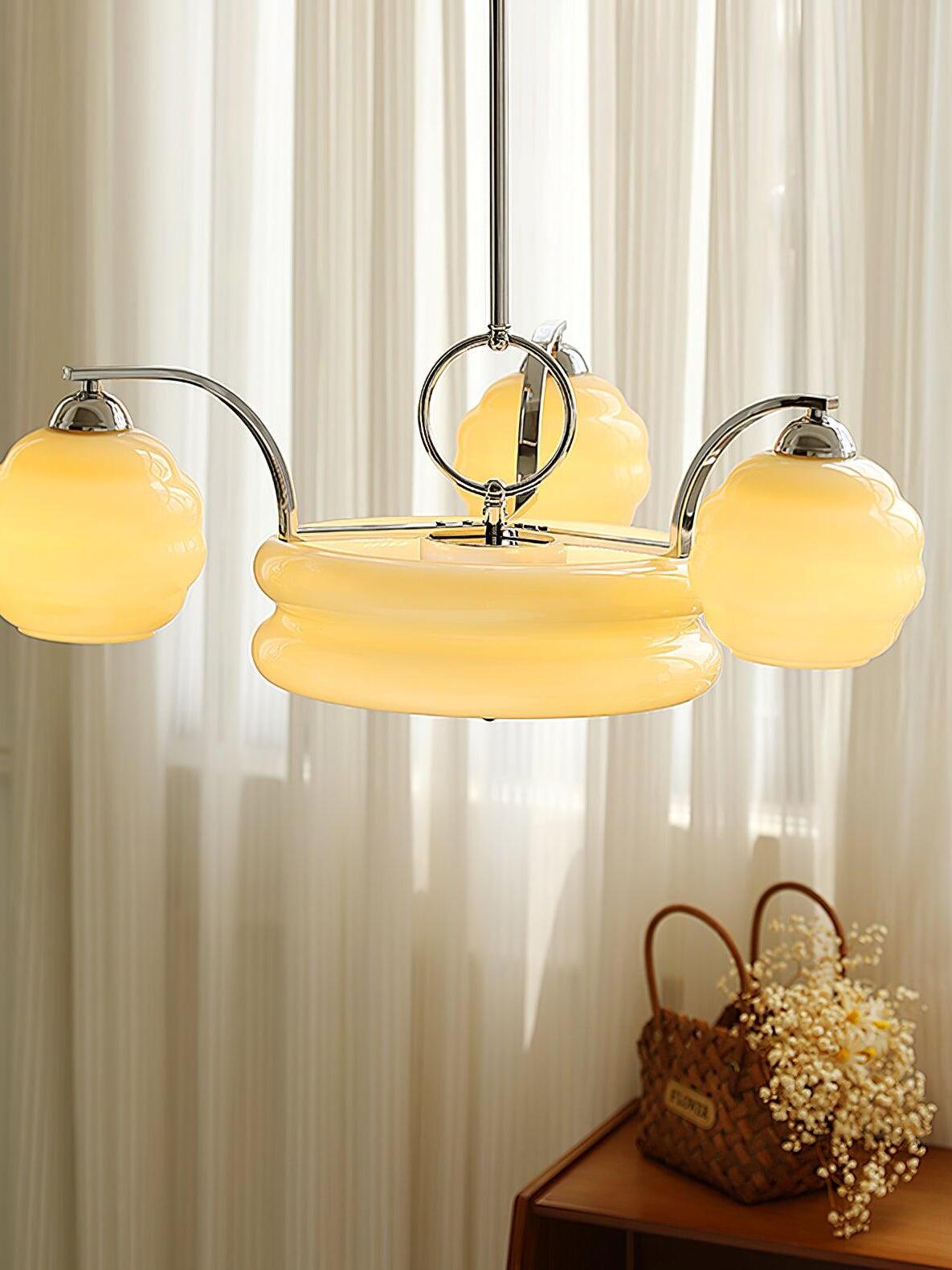 Chrome-framed chandelier beside sheer curtains