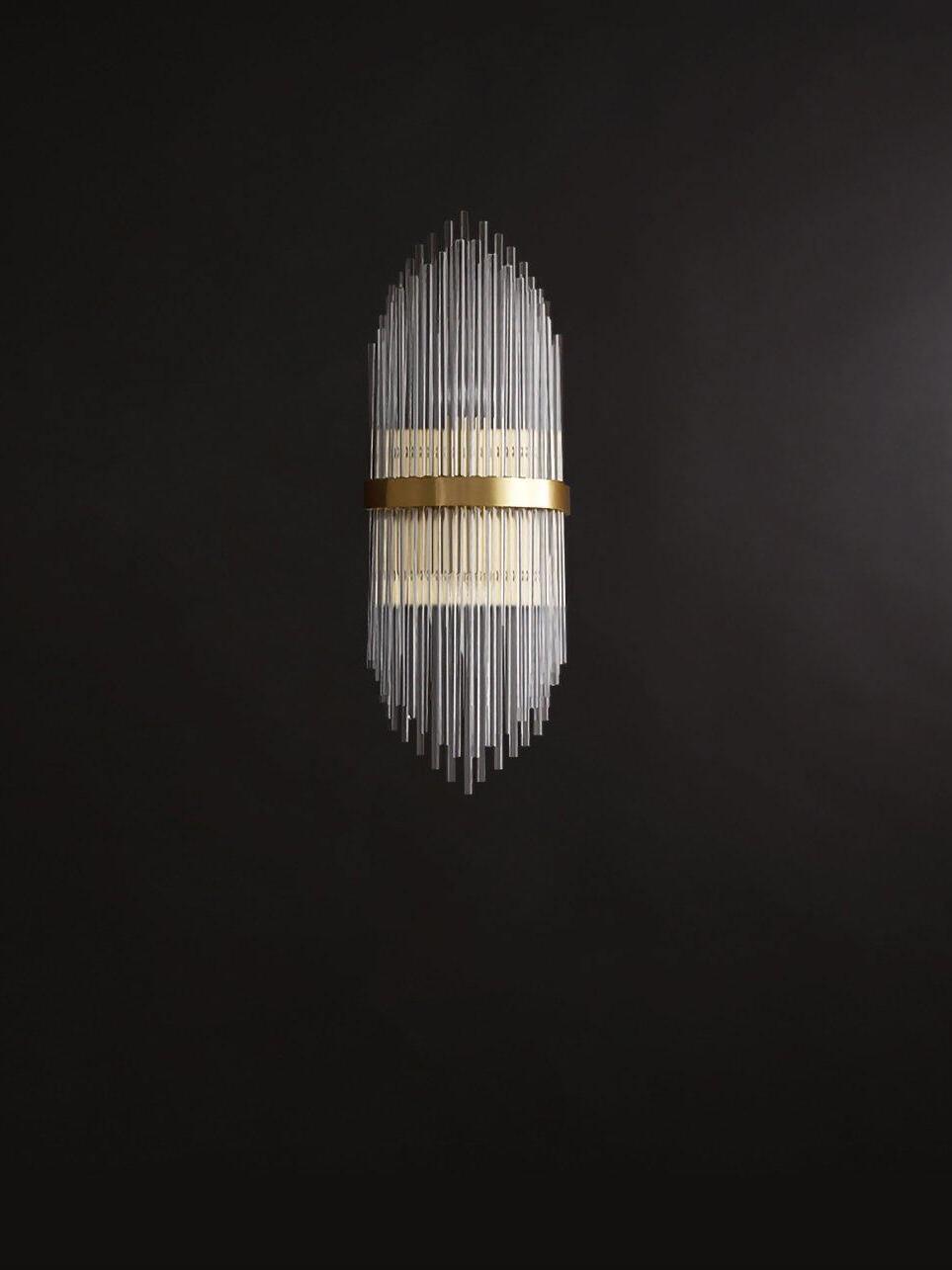 Small lit brass-band wall sconce centred on dark wall