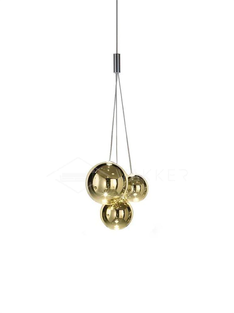 Gold three-globe glass pendant on white with shiny gold-tone spheres of different sizes and a chrome junction