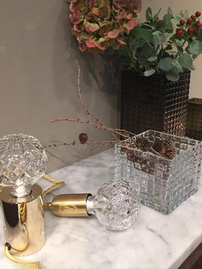 Clear globe table lamp with loose shade and metal parts on marble